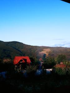 eine rote Scheune inmitten eines Berges in der Unterkunft Садиба на Хуторі in Solotschyn
