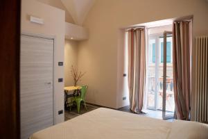 1 dormitorio con cama, ventana y mesa en Le Caravelle Affittacamere, en Génova
