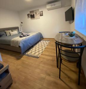 1 dormitorio con 1 cama y 1 mesa con silla en Greg's Rooms, en Ilirska Bistrica