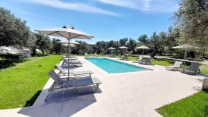 a swimming pool with lounge chairs and an umbrella at Lyrids Apartments in Episkopí- Rethimno