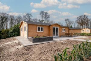 ein winziges Haus mit einer Terrasse im Hof in der Unterkunft Recreatiepark Maas en Bos in Wellerlooi