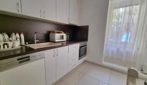 a kitchen with white cabinets and a sink and a window at Spacious apartment in CITY CENTER in Bratislava