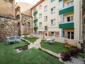 a courtyard with chairs and tables in a building at Apartantiguo San Isidoro10 in Oviedo