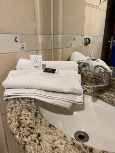 a bathroom sink with towels on top of it at Riviera Hotel in Brasília