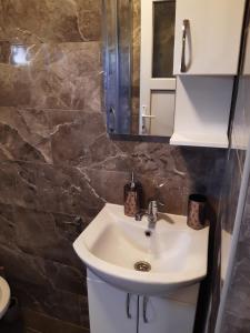 a bathroom with a sink and a mirror at Apartments Mušović in Bar