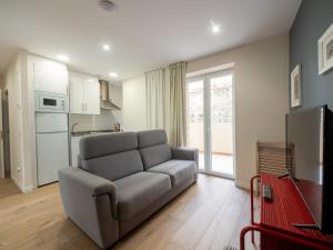 a living room with a couch and a kitchen at Apartantiguo San Isidoro10 in Oviedo
