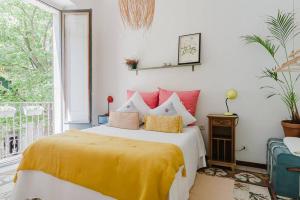 a bedroom with a bed with yellow and red pillows at Habitación en La Rambla in Girona