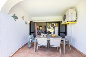 een keuken en eetkamer met een tafel en stoelen bij Muito Sol in Albufeira