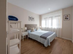 a white bedroom with a bed and a window at Apartantiguo San Isidoro10 in Oviedo