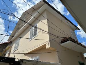 un bâtiment avec des fenêtres et des fils devant lui dans l'établissement Andrea House, à Berat