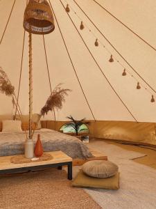 Zimmer mit einem Zelt mit einem Bett und einem Tisch in der Unterkunft Amberhouse Glempings 