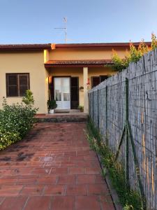a house with a fence and a brick driveway at Casa giardino santadi in Santadi