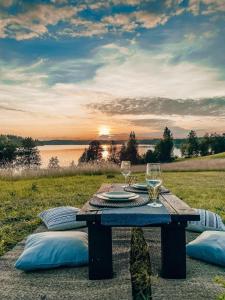 a wooden table with plates and wine glasses on it at Amberhouse Glempings in Piejūti +11 photos