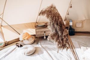 a room with a tent with a table and a bed at Amberhouse Glempings in Piejūti