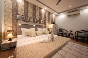 a bedroom with a large bed with two stuffed animals on it at Perfectstayz Homes I Luxury Penthouse in Haridwār