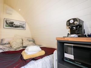 a small room with a bed and a television at The South Lodge Retreat in East Grinstead