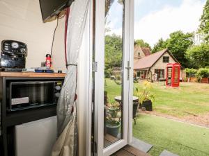 uma porta aberta para um jardim com uma cabina telefónica em The South Lodge Retreat em East Grinstead