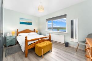 a bedroom with a bed and a chair and a window at Cottage 439 - Clifden in Clifden