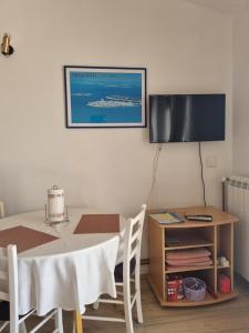 ein Esszimmer mit einem Tisch und einem TV an der Wand in der Unterkunft APARTMANI TONI POCE 2 in Primošten