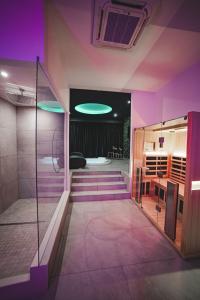 bagno con illuminazione viola e cabina doccia di Capri Spa Hotel a Casoria