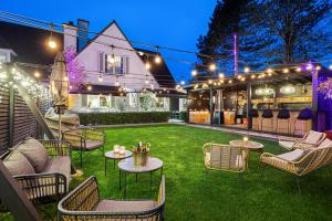 a backyard with chairs and tables and lights at Villa Alba in Bilzen