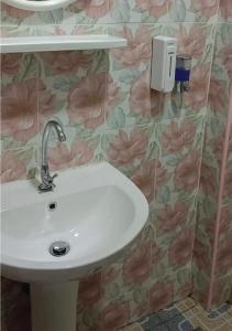 - un lavabo dans la salle de bains avec des fleurs roses sur le mur dans l'établissement JUNPEN RESORT, à Ban Hai Yong