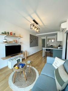 Una sala de estar con un sofá azul y una mesa. en Le Pagnol - Hyper centre - Clim, en Cassis