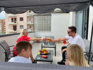 a group of people sitting around a table on a balcony at Apartment Aulona Park in Vlorë