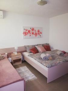 ein Schlafzimmer mit einem Bett und einem Tisch in einem Zimmer in der Unterkunft Apartman "Vuković" in Bizovac