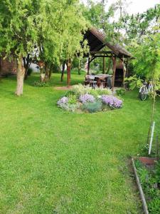 a gazebo with a picnic table in a yard at Apartman "Vuković" in Bizovac