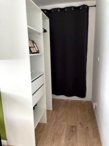 a closet with a black curtain in a room at Studio indépendant in Andilly-les-Marais
