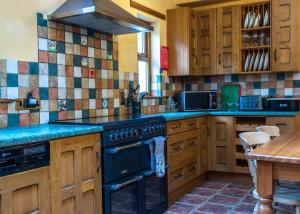 a kitchen with a black stove top oven next to a table at Ferroch the place with an amazing view! in Torridon