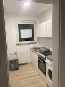 a kitchen with a stove and a sink and a dishwasher at Schöne Appartement mit kostenlosen Parkplätze AVD1 in Gelsenkirchen +9 photos