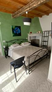 una camera con un grande letto e una sedia di B&B Gronda Via Vandelli a Massa