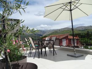 a patio with a table and chairs and an umbrella at Modernes Kleines Haus mit Terrasse in Split