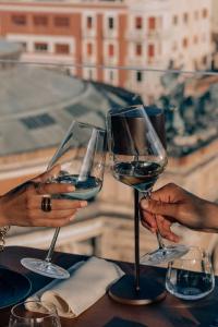 two people holding up wine glasses on a table at Hotel Politeama in Palermo