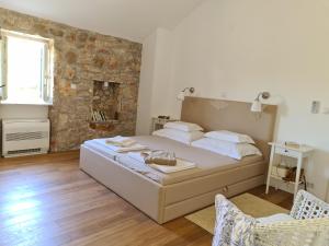 a bedroom with a large bed and a stone wall at Villa stone house in Ugljan +41 photos
