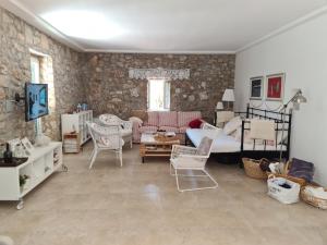 a living room with a bed and chairs in it at Villa stone house in Ugljan