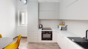 een keuken met witte kasten en een fornuis met oven bij Deventer Residence VRT in Sibiu