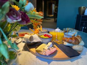 una mesa con productos de desayuno en una mesa con flores en Villa Alba en Bilzen