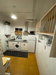 a kitchen with white cabinets and a washer and dryer at Six wine lovers in Logroño in Logroño