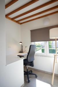 una oficina con escritorio, silla y ventana en Apartment with a view and parking, en Brecht
