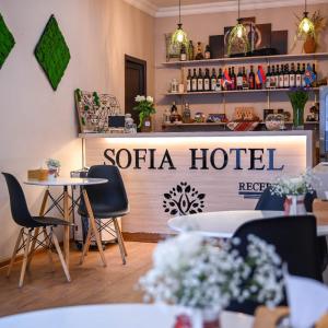 a restaurant with tables and chairs and a hotel sign at Sofia Hotel in Yerevan