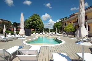 a pool with chairs and umbrellas in a resort at Hotel Ristorante Dante in Torgiano