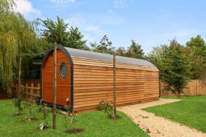un grande capannone in legno in un cortile alberato di Laburnum Farm Estate a Alderton