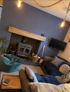 a living room with two couches and a fireplace at Relaxing Riverside Cottage in Llangwm