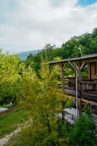 a wooden bridge over a river with a picnic table at Ferma Albanik in Këlcyrë +41 photos