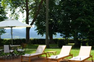 a group of chairs and a table with an umbrella at HOTEL BOUTIQUE VILLA DEL MARQUÉS in Muros de Nalón