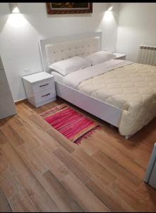 1 dormitorio con 1 cama grande y suelo de madera en Villa Goliku en Peshtan