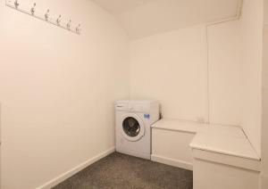 a white laundry room with a washing machine in it at The Rosary Rest in Norwich